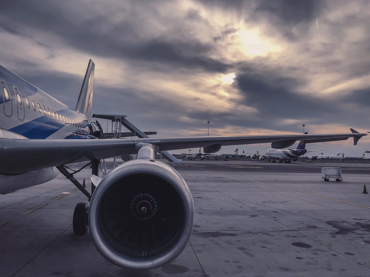 Commercial aircraft in flight over clouds at sunset